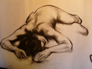 Life drawing of a nude female model on her belly, lying with her head cradled in her arms so we cannot see her head-first toward the artist. The image is drawn in black on a yellowed background. Image found on Flickr, uploaded by fairsquare. A link is provided at the bottom of the post.