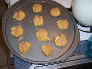 Doughnut puffs, uncooked, on pan and topped with cinnamon sugar. Image by Anna Cook.